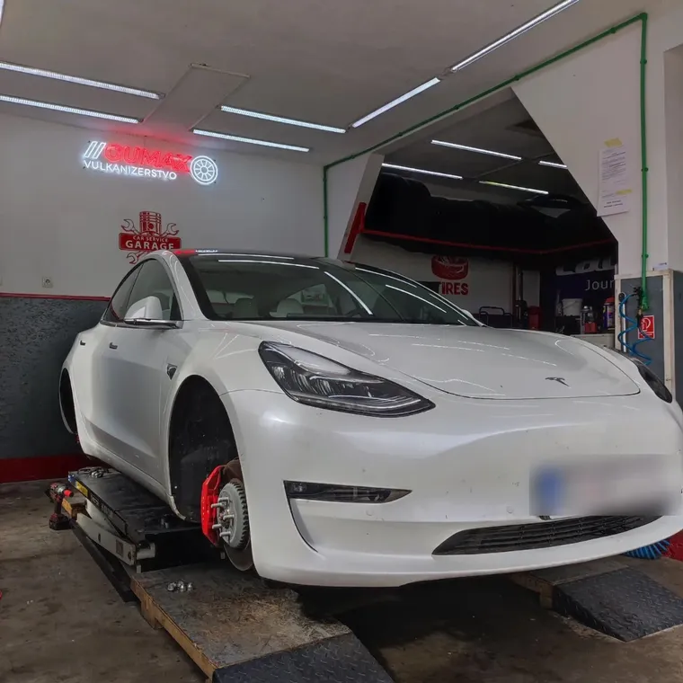 Tesla Model 3 na dizalici ispod GUMAX neona